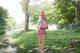 A girl with a backpack standing in the middle of a forest.