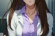 A woman with long brown hair wearing a white lab coat.