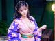 A woman in a purple kimono posing for a picture.