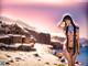 A woman in a bikini standing on a beach.