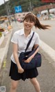 A woman in a school uniform is walking down the street.