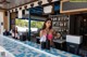 A woman standing behind a counter in a restaurant.